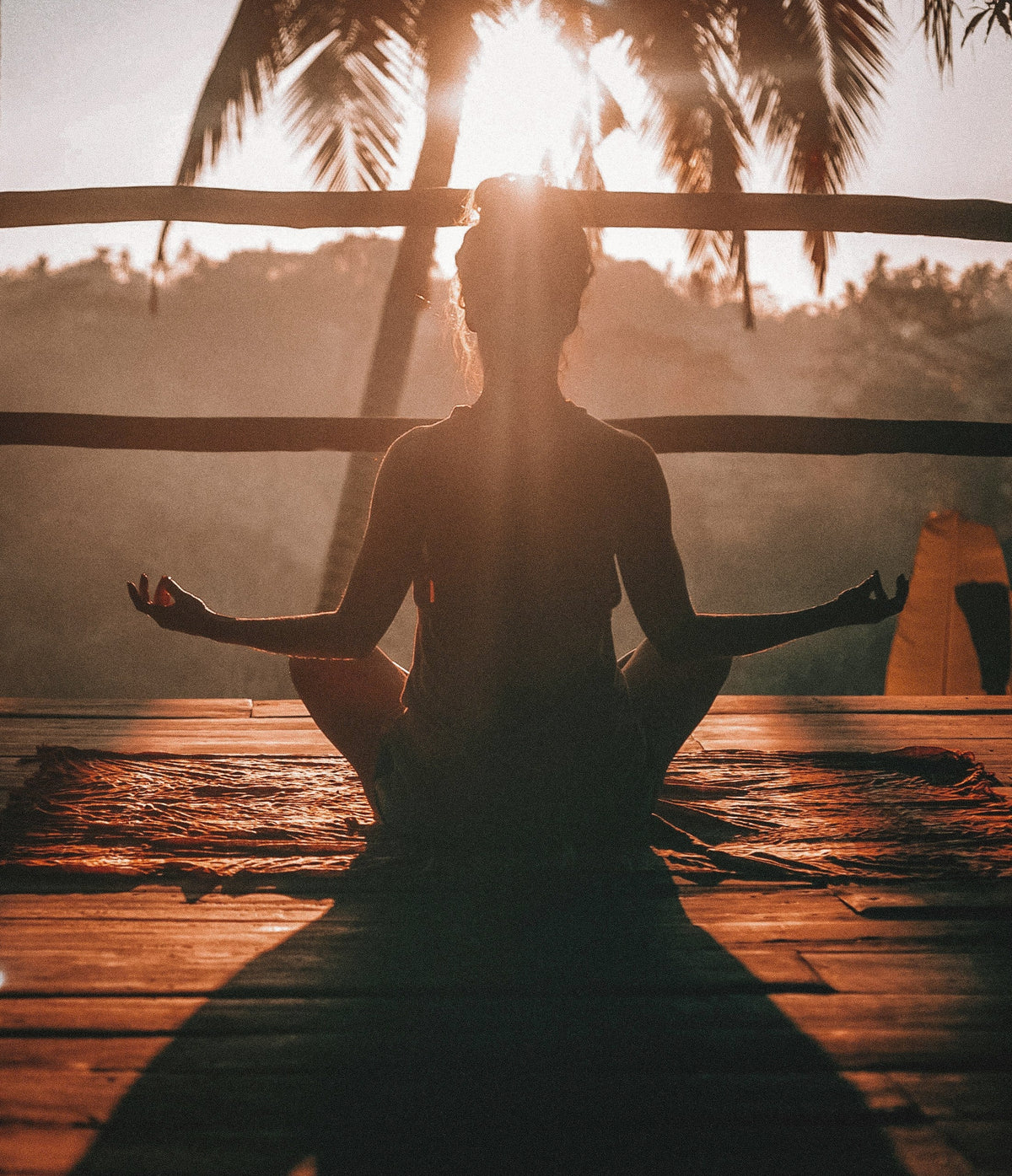 Woman doing yoga on a porch in a tropical setting
