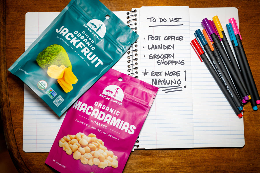 Mavuno jackfruit and macadamia packages beside a notebook