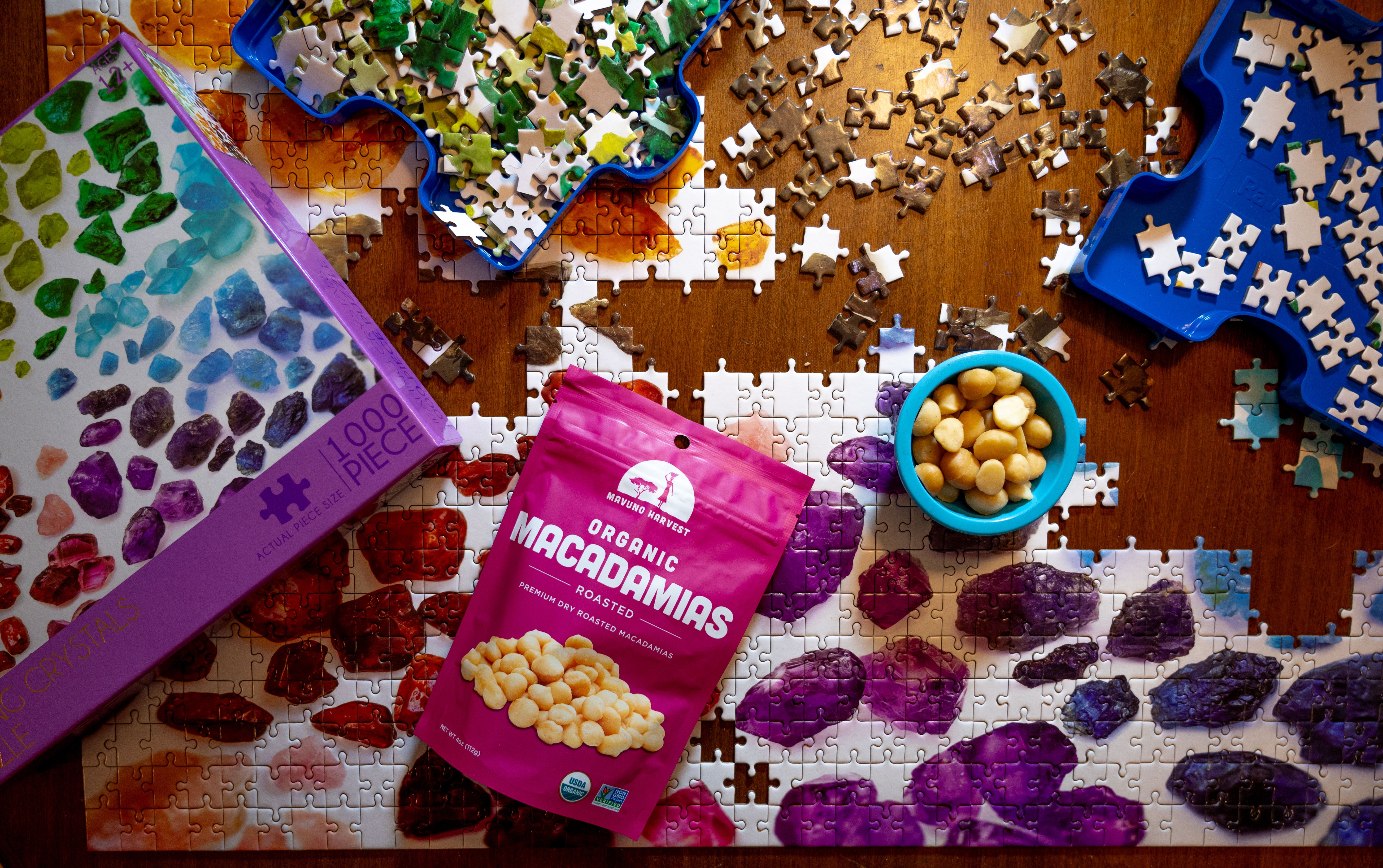 Mavuno roasted macadamias pouch beside a bowl of macadamias during a puzzle