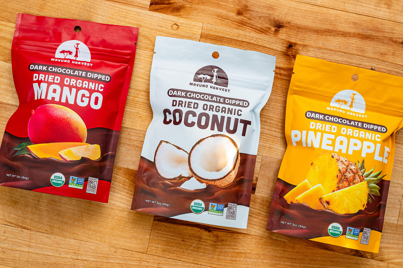 Mavuno dark-chocolate-dipped mango, coconut, and pineapple bags on a wooden table