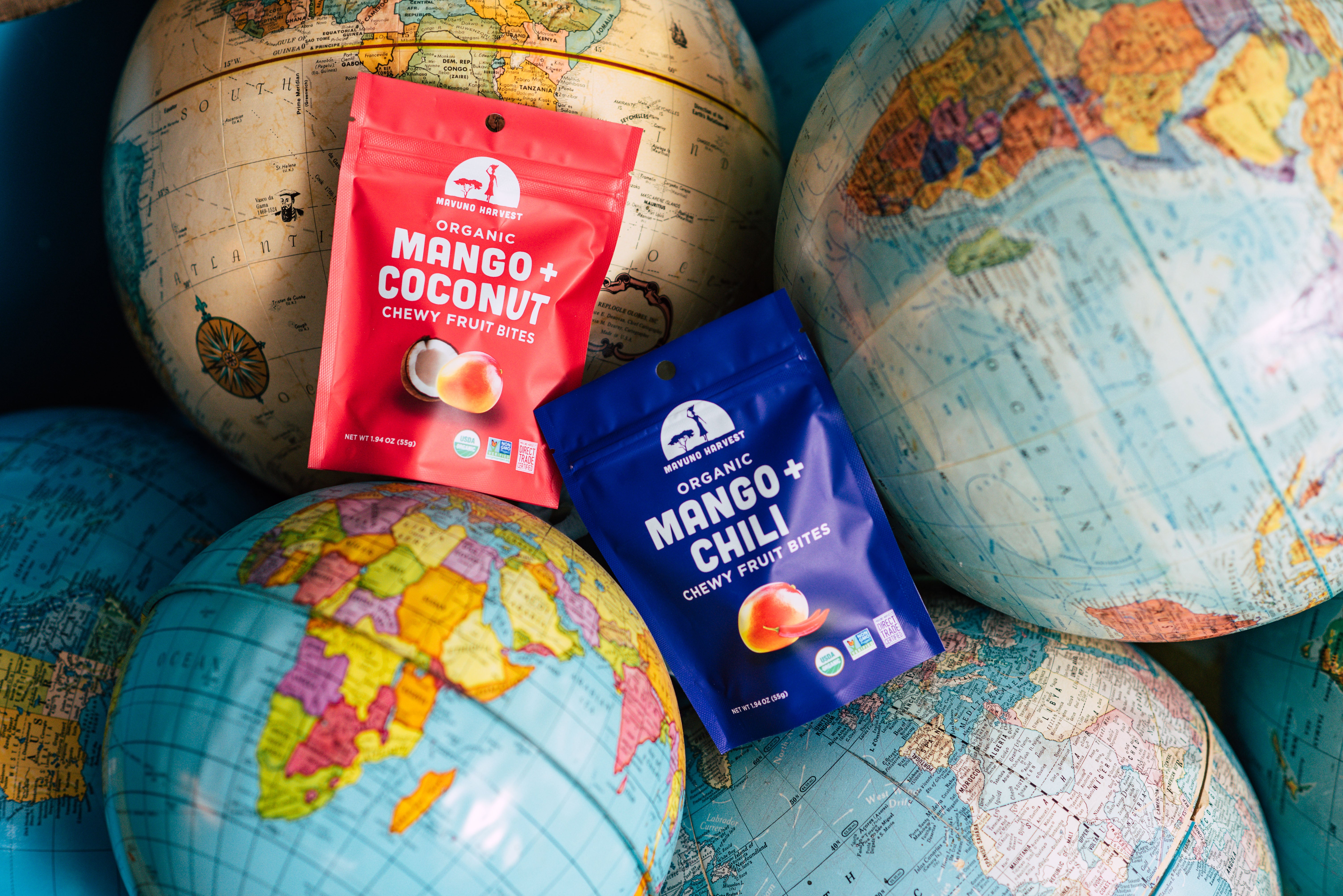 Mavuno Mango and Coconut and Mango and Chili fruit bites among colorful globes